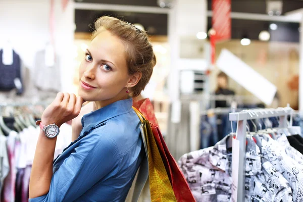 Kvinna i en butik köper kläder — Stockfoto
