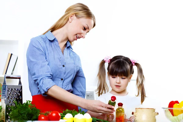 Mladá matka vaření doma s její daoghter — Stock fotografie
