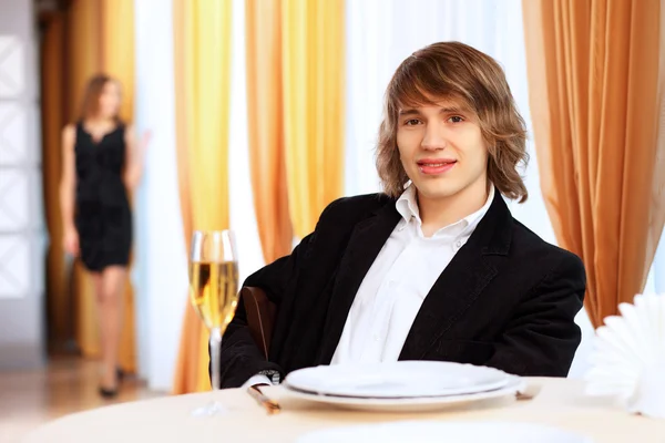Jovem homem bonito sentado no restaurante — Fotografia de Stock