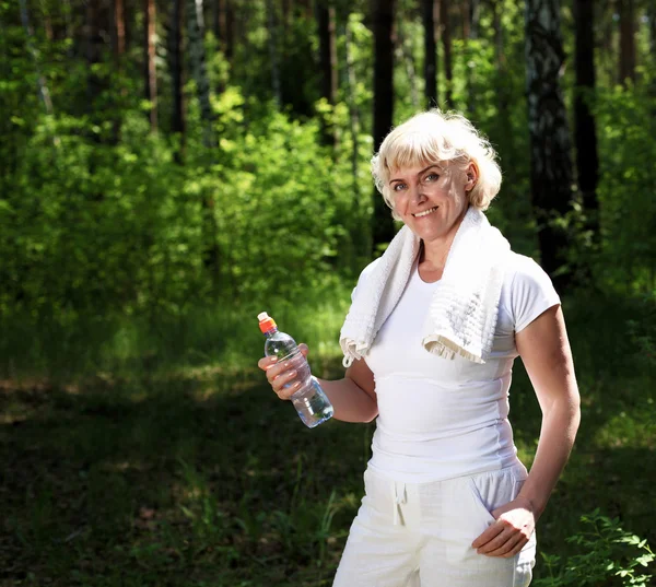Mujer mayor después de hacer ejercicio en el bosque —  Fotos de Stock
