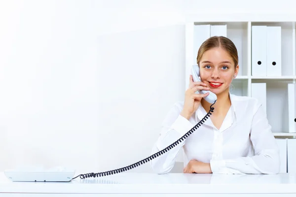 Mujer joven con un teléfono en la oficina —  Fotos de Stock