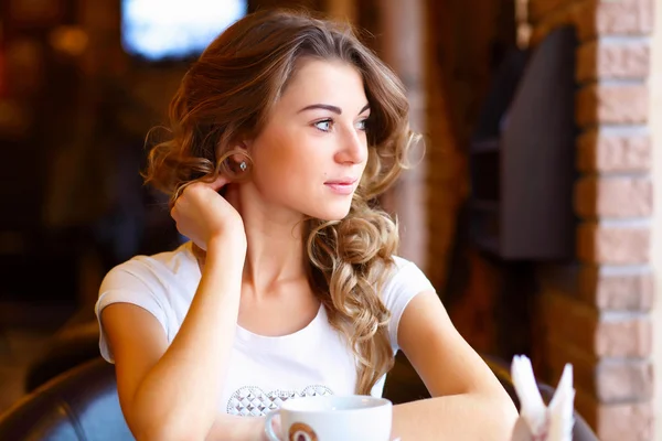 Jeune jolie femme assise au restaurant — Photo