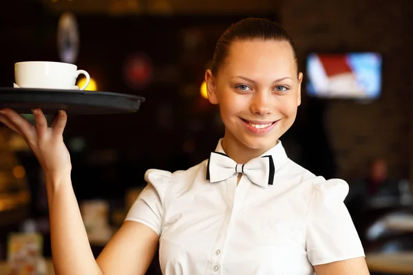 Retrato de una joven camarera sosteniendo una bandeja — Foto de Stock