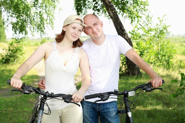 Mladý pár na kolech v parku — Stock fotografie
