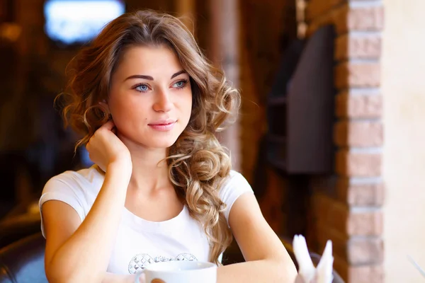 Νεαρή όμορφη γυναίκα που κάθεται στο εστιατόριο — Φωτογραφία Αρχείου