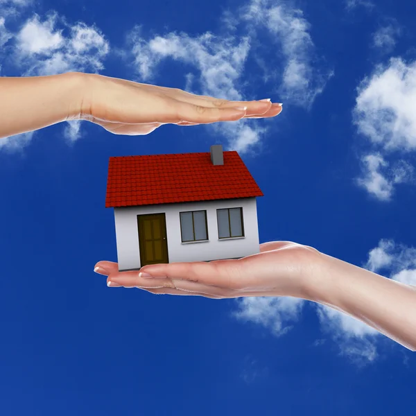 Dom i ludzką ręką przeciw błękitne niebo — Zdjęcie stockowe