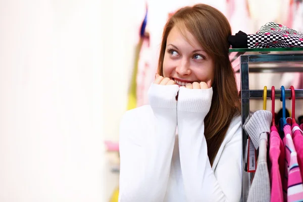 Молода жінка в магазині купує одяг — стокове фото