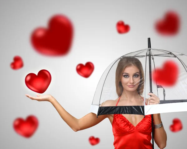 Красивая молодая женщина с зонтиком и сердцами — стоковое фото