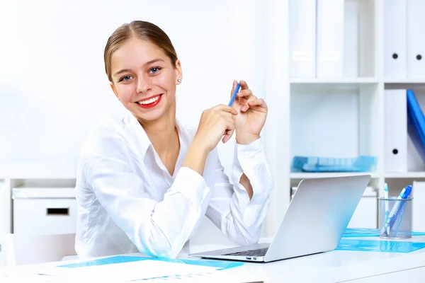 Jonge vrouw in zakelijke slijtage werken in office — Stockfoto