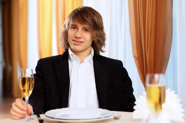 Молодой красивый мужчина сидит в ресторане — стоковое фото