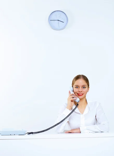 Молодая женщина с телефоном в офисе — стоковое фото