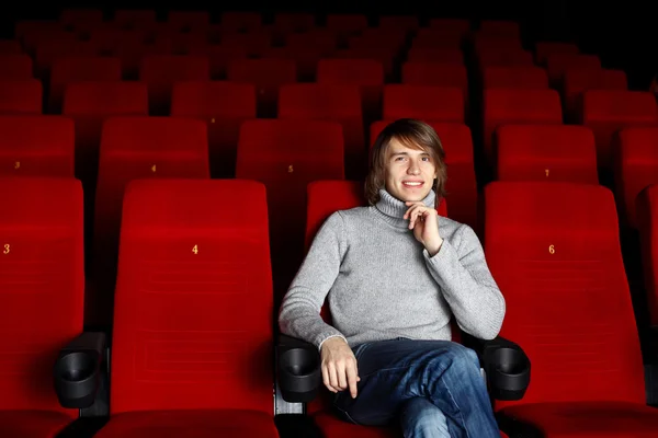 年轻男子坐在一个人看电影 — 图库照片