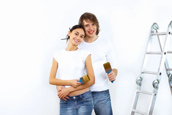 Casal jovem com pincéis de pintura juntos — Fotografia de Stock