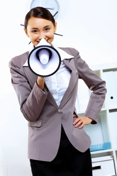 Jonge vrouw met megafoon in office — Stockfoto