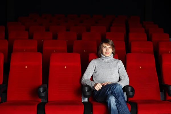 Young man sitting in the cinema alone — Stock Photo, Image
