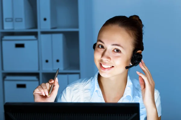 Young woman in business wear and headset Stock Picture