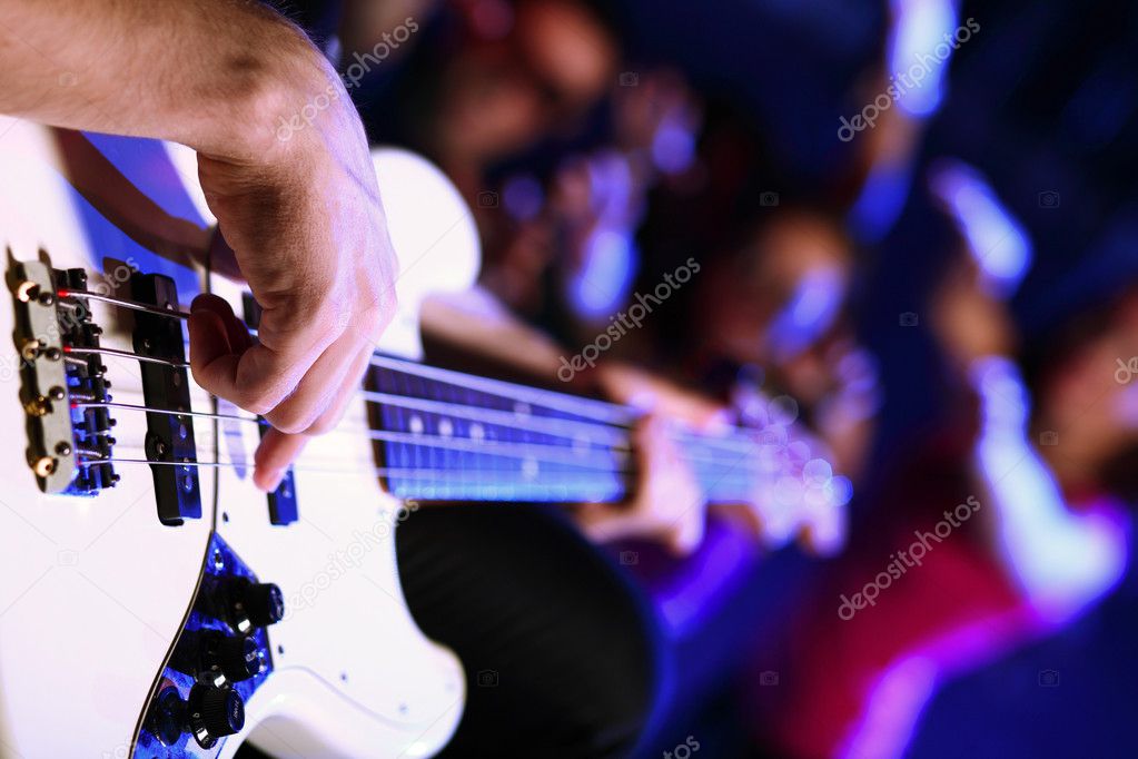 Young guitar player performing in night club