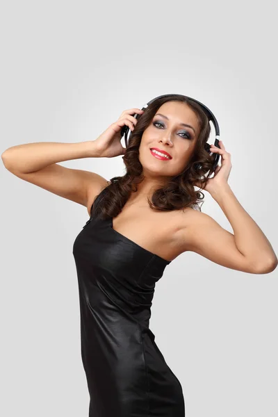 Молода жінка в вечірній сукні з навушниками — стокове фото