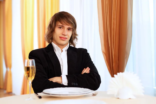 Jonge knappe man zittend in restaurant — Stockfoto