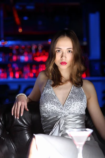 Young woman in night club with a drink — Stock Photo, Image