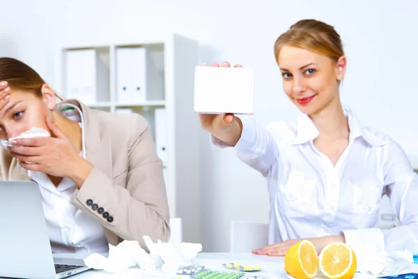 Woman in office holding a pack of medicine — Stock Photo, Image