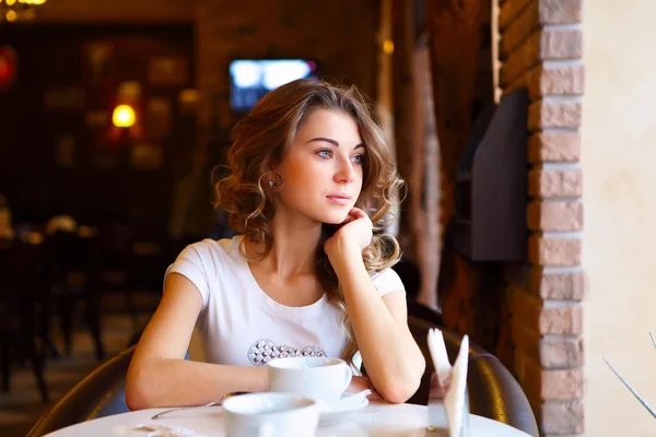 Mladá krásná žena, sedící v restauraci — Stock fotografie