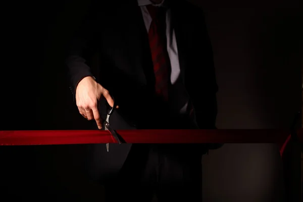 stock image Businessman with scissors cuting a red ribbon