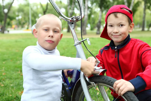 Menino em uma bicicleta no parque verde — Fotografia de Stock