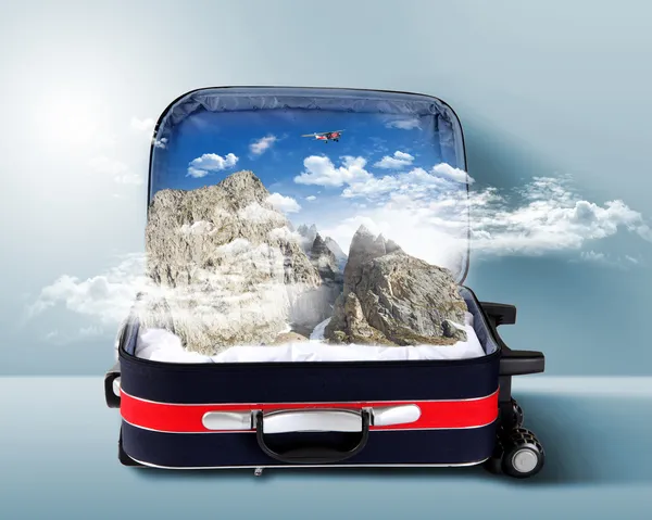 Красный чемодан со снежными горами внутри — стоковое фото