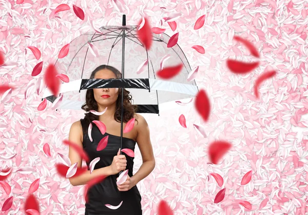 Όμορφη γυναίκα κάτω από ομπρέλα με πέταλα γύρω της — Φωτογραφία Αρχείου