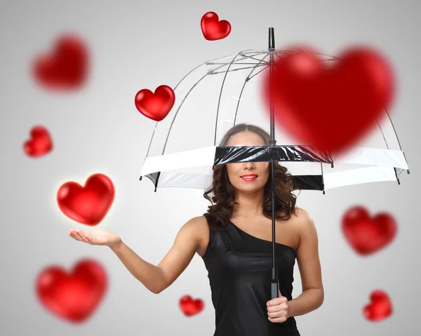 Ganska ung kvinna med paraply och hjärtan — Stockfoto