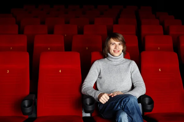 Junger Mann sitzt allein im Kino — Stockfoto