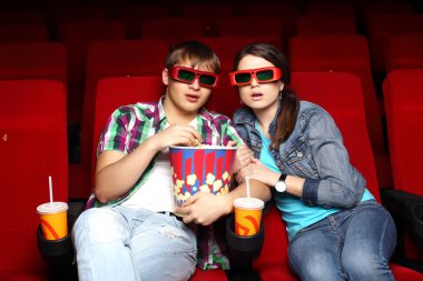 Young couple in cinema watching movie clipart