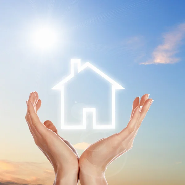 Haus und menschliche Hand gegen blauen Himmel — Stockfoto