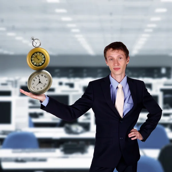 Бізнесмен в офісі тримає піраміду годинника — стокове фото