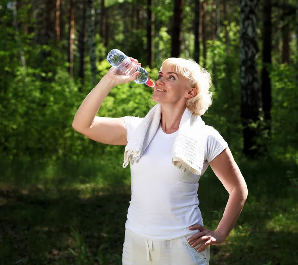 Elderly woman after exercising in the forest — Stock Photo, Image