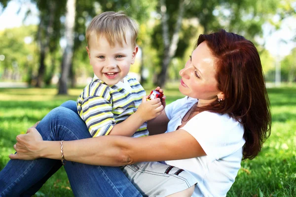 Giovane madre con suo figlio nel parco estivo — Foto Stock