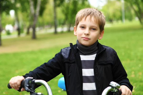 Мальчик на велосипеде в зеленом парке — стоковое фото
