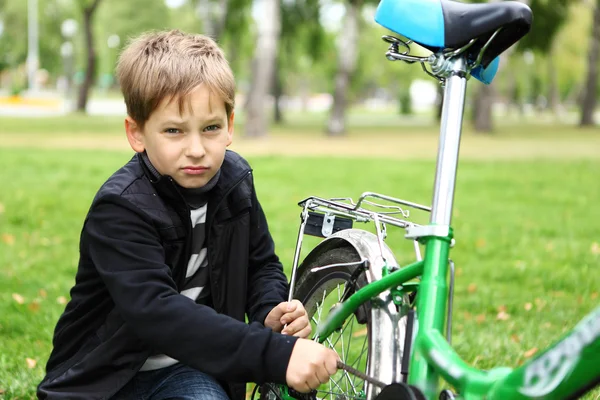 Garçon sur un vélo dans le parc vert — Photo