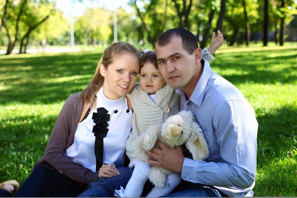 Jonge gezin met dochtertje in zomer park — Stockfoto