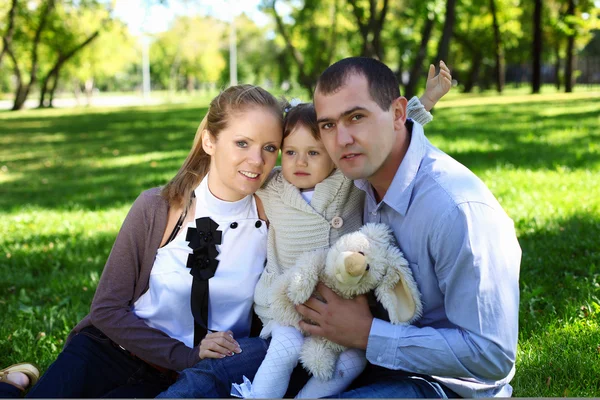 Família jovem com filha pequena no parque de verão — Fotografia de Stock