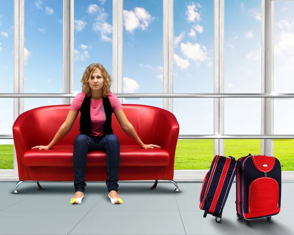 Mujer joven sentada en un sofá en el aeropuerto — Foto de Stock