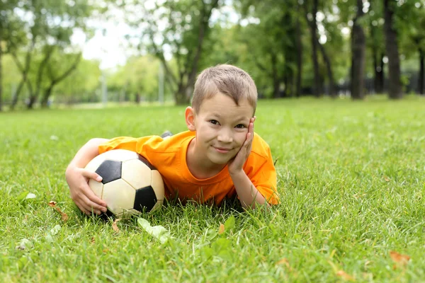 Mały chłopiec w parku z piłką — Zdjęcie stockowe