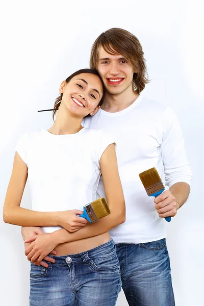 Young couple with paint brushes together — Stock Photo, Image