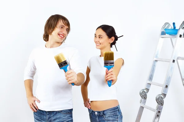 年轻夫妇用油漆刷在一起 — 图库照片