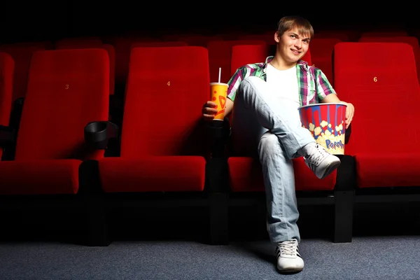 Молодой человек в кино смотрит кино — стоковое фото
