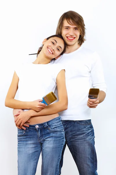 Unga par med penslar tillsammans — Stockfoto