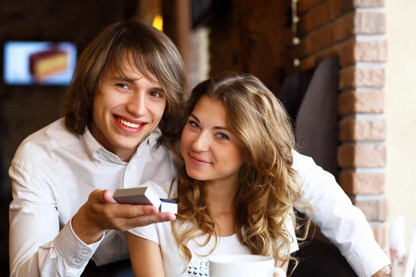 Pasangan muda dengan cincin pertunangan di restoran — Stok Foto
