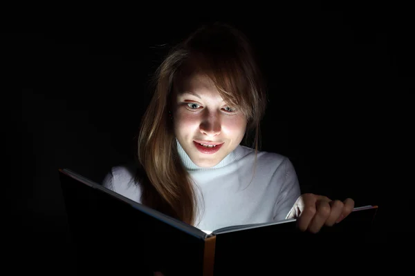 Молода жінка читає чарівну книгу — стокове фото