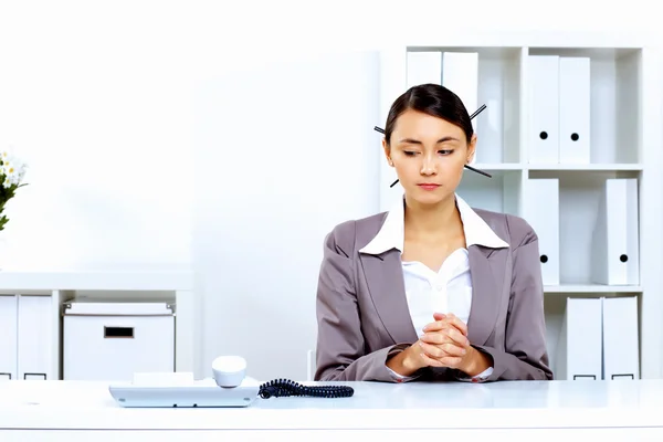 Young woman with a phone in office — Stock Photo, Image